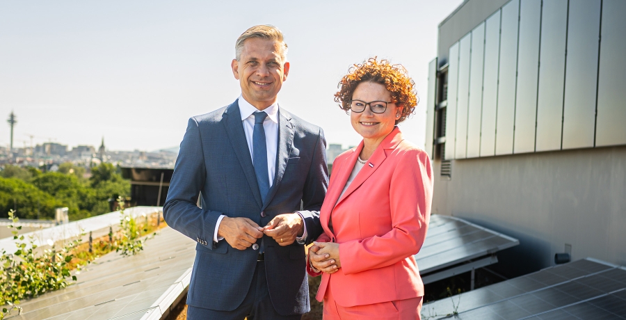 Bundesminister Hattmannsdorfer und Staatssekretärin Zehetner vor einer PV-Anlage auf einem Dach in Wien