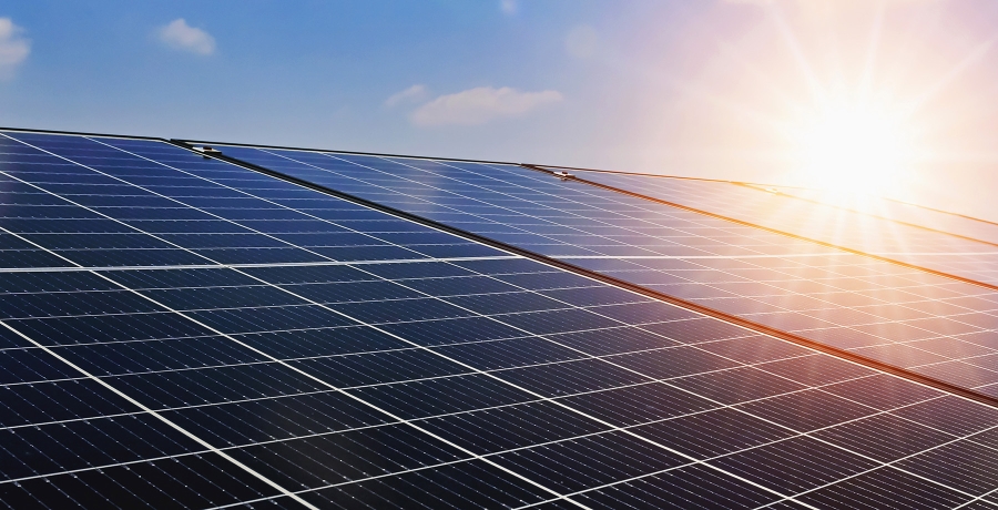 Solarpanele auf einem Dach mit Sonne im Hintergrund