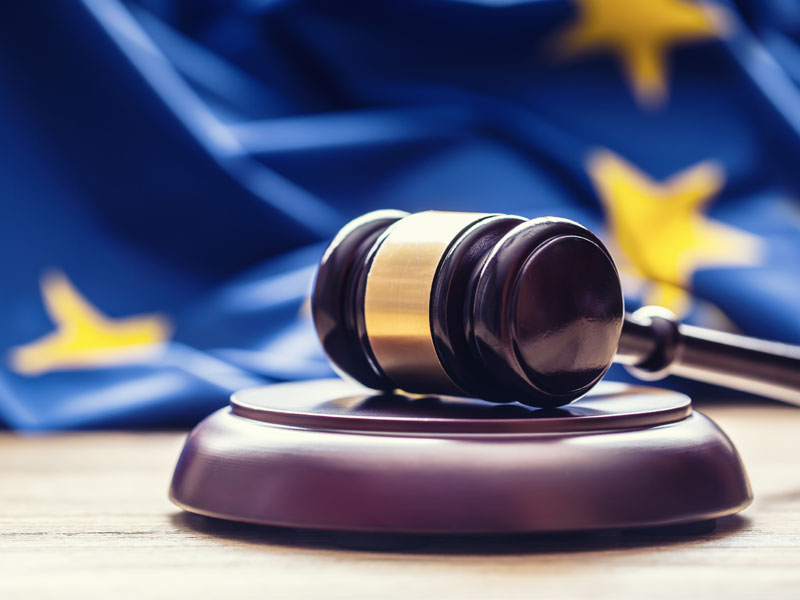 Judges wooden gavel with EU flag in the background. Symbol for jurisdiction.